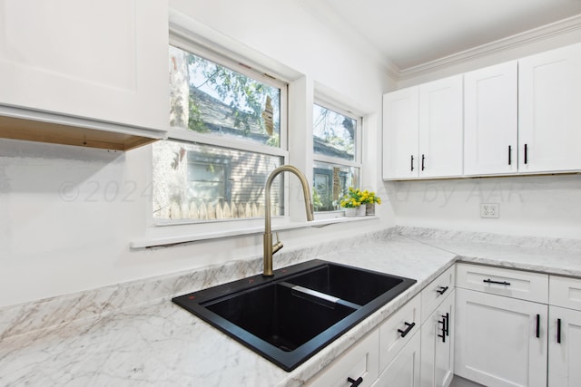 818 N Someville St, Pampa, TX 79065 - kitchen with light stone counters, a sink, white cabinetry, and ornamental molding