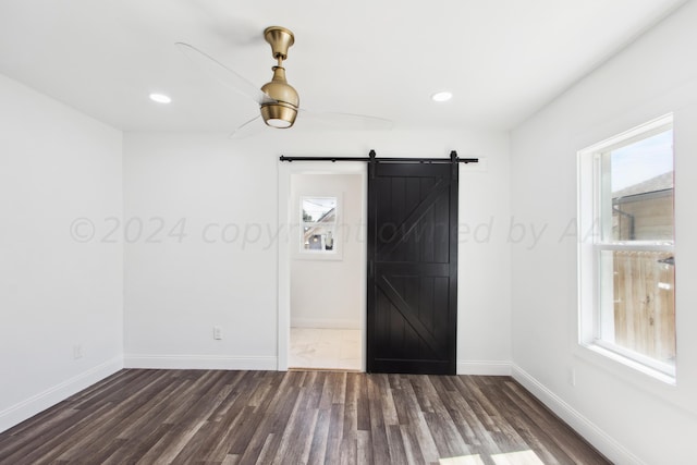 818 N Someville St, Pampa, TX 79065 - empty room with dark wood-style flooring, baseboards, a barn door, and a wealth of natural light