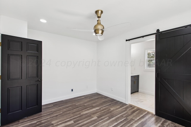 818 N Someville St, Pampa, TX 79065 - empty room with dark wood-style flooring, baseboards, ceiling fan, recessed lighting, and a barn door