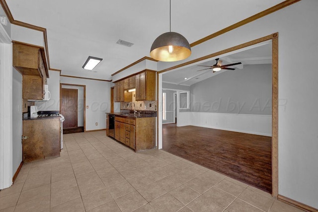 7935 Mitcham Dr, Amarillo, TX 79121 - kitchen featuring a sink, dishwasher, a ceiling fan, dark countertops, and brown cabinets