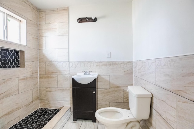 bathroom with tile walls, vanity, and toilet