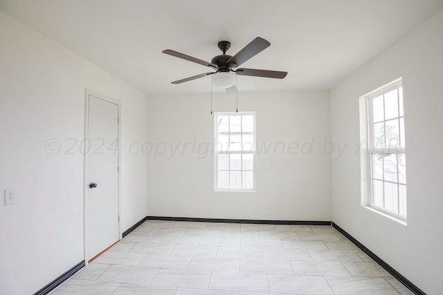 unfurnished room featuring a wealth of natural light and ceiling fan