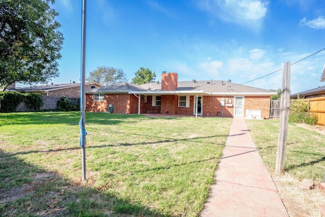 ranch-style house with brick siding, a front lawn, fence, and a chimney