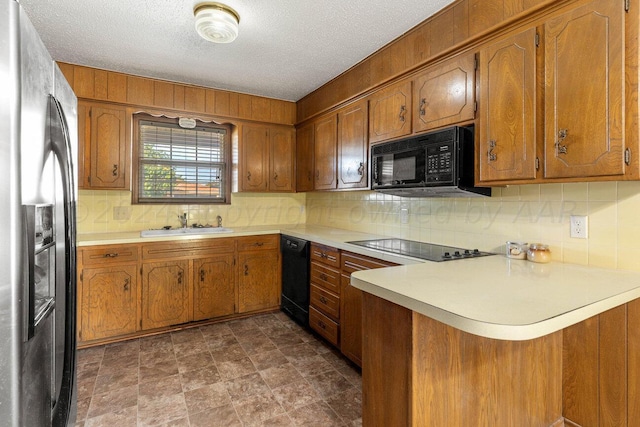 kitchen featuring brown cabinets, backsplash, and black appliances