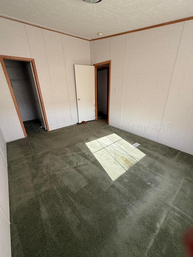 1046 S Farley St, Pampa, TX 79065 - unfurnished bedroom with a textured ceiling, carpet flooring, crown molding, and a decorative wall