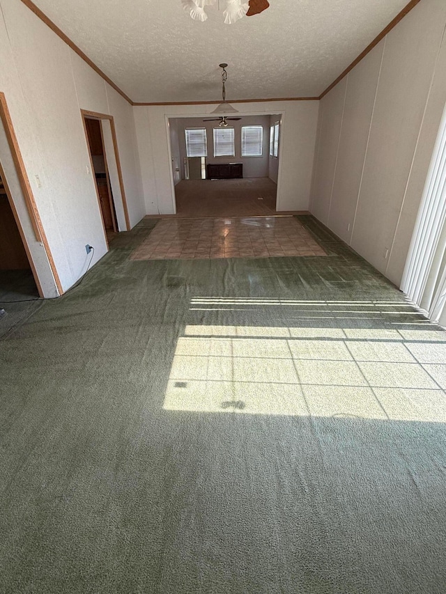 1046 S Farley St, Pampa, TX 79065 - carpeted empty room with ornamental molding, a ceiling fan, a decorative wall, and a textured ceiling