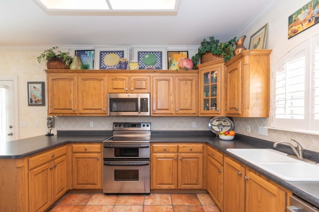 6504 Bayberry Ln, Amarillo, TX 79124 - kitchen featuring appliances with stainless steel finishes, a sink, ornamental molding, a peninsula, and glass insert cabinets