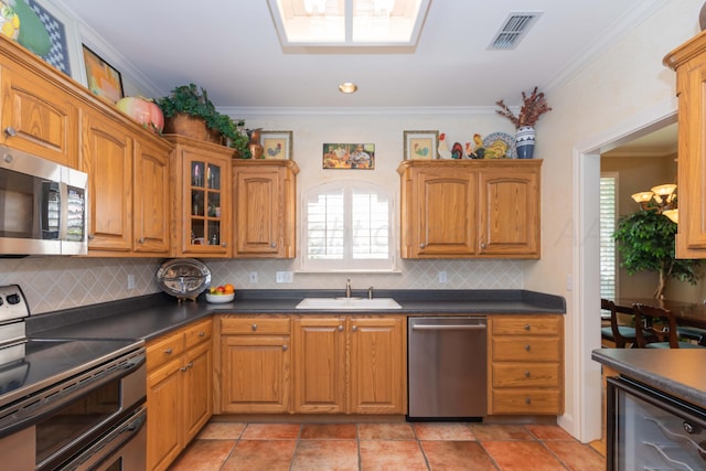 6504 Bayberry Ln, Amarillo, TX 79124 - kitchen with stainless steel appliances, a sink, crown molding, decorative backsplash, and dark countertops
