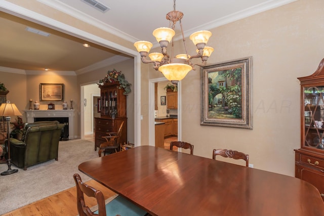 6504 Bayberry Ln, Amarillo, TX 79124 - dining space featuring crown molding, a chandelier, light wood finished floors, and a fireplace