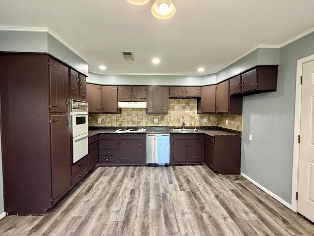 604 Montana St, Borger, TX 79007 - kitchen featuring white appliances, a sink, dark countertops, tasteful backsplash, and crown molding