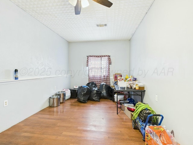 interior space featuring wood finished floors, visible vents, and ceiling fan