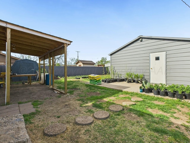 view of yard featuring an outdoor structure and fence