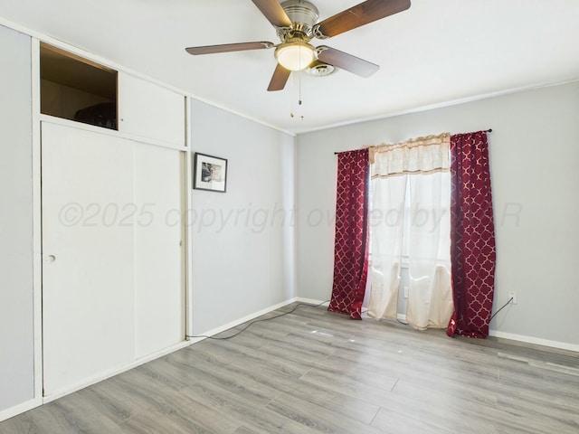unfurnished bedroom featuring baseboards, ceiling fan, and light wood-style floors