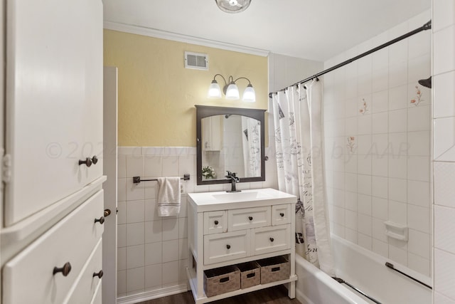 bathroom featuring hardwood / wood-style floors, vanity, shower / tub combo, and tile walls