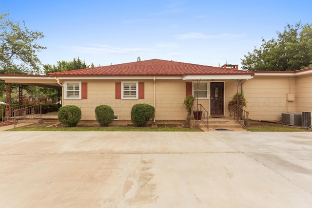 ranch-style house with a carport and cooling unit