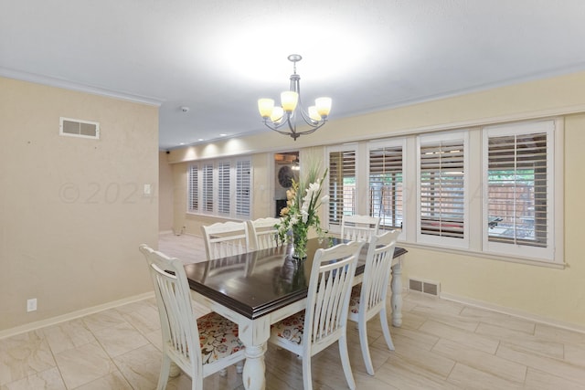 dining space featuring ornamental molding and a notable chandelier