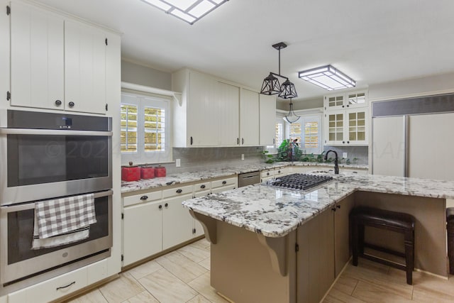 kitchen featuring pendant lighting, backsplash, stainless steel appliances, and a breakfast bar area