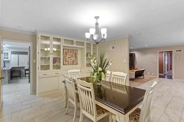 dining room with ornamental molding and a chandelier