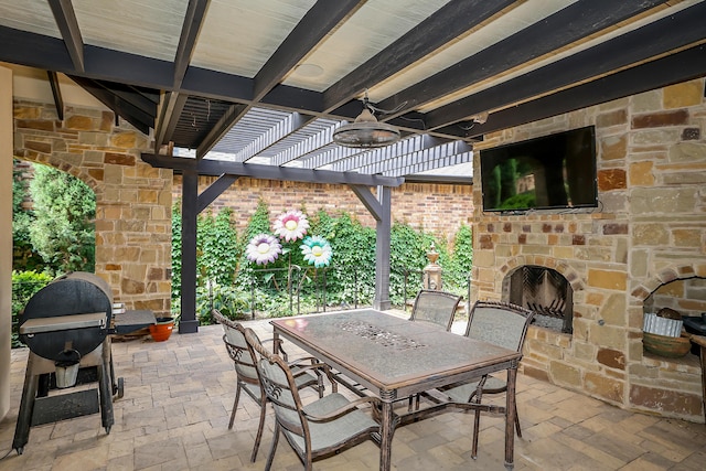 view of patio / terrace with a pergola, ceiling fan, a grill, and an outdoor stone fireplace