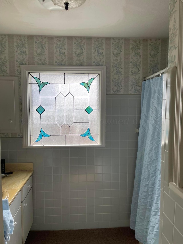 bathroom with a shower with shower curtain, vanity, and tile walls