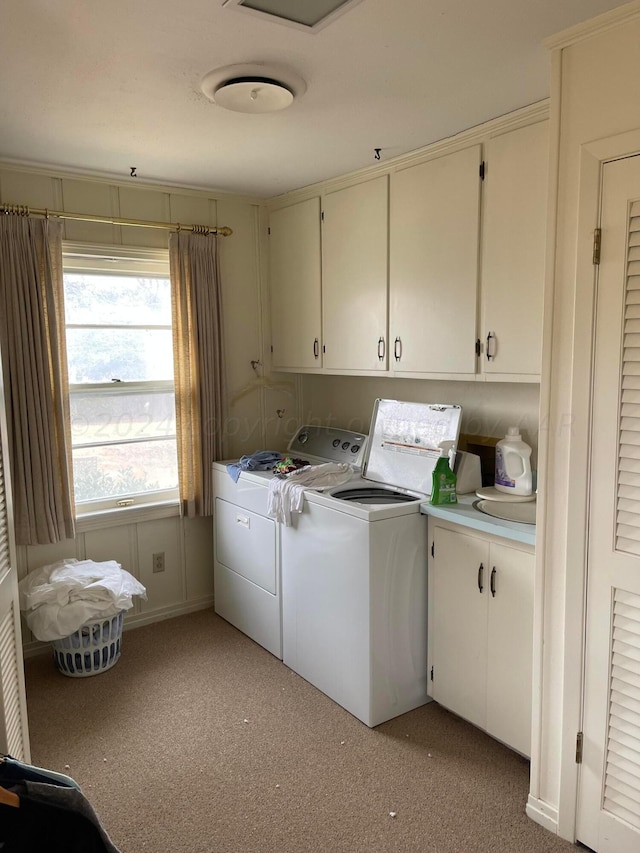 laundry room featuring washing machine and dryer, cabinets, and light carpet