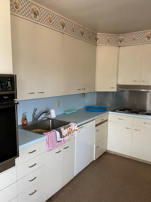 kitchen featuring dark colored carpet, sink, white cabinetry, white appliances, and decorative backsplash