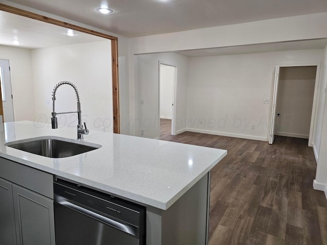 kitchen featuring a sink, light stone counters, dark wood finished floors, stainless steel dishwasher, and baseboards