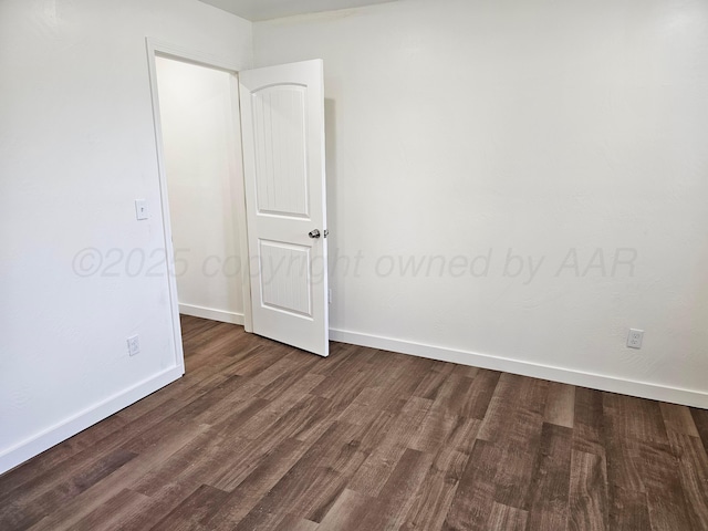 empty room featuring baseboards and wood finished floors