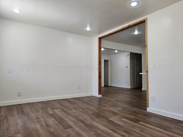 empty room featuring baseboards, dark wood-style floors, and recessed lighting