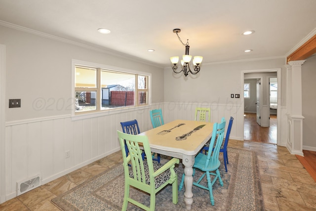 dining area featuring a notable chandelier, ornamental molding, decorative columns, and a wealth of natural light