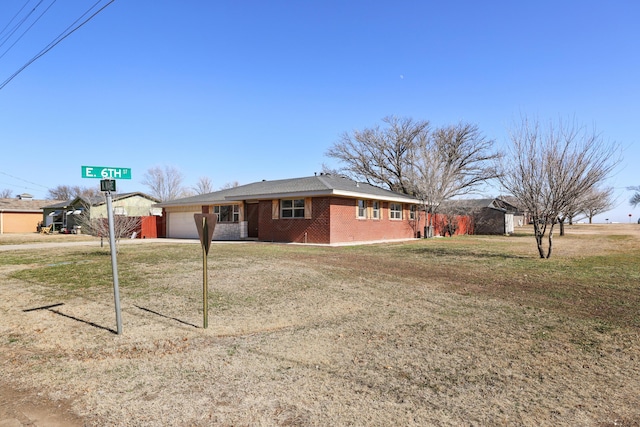 single story home with a garage and a front lawn