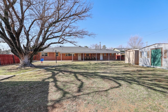 rear view of house featuring a storage shed and a yard