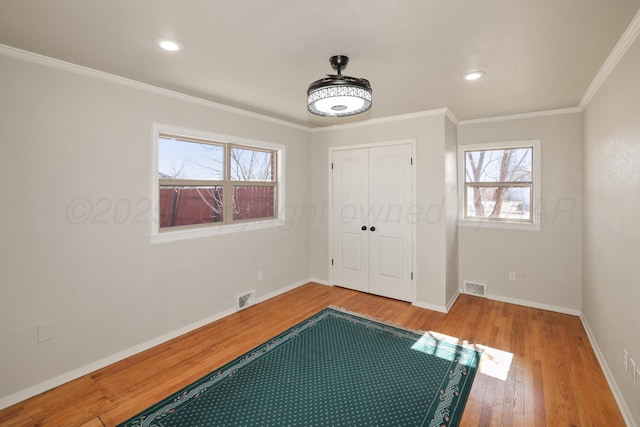 entryway with hardwood / wood-style flooring and crown molding