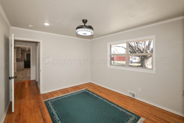 spare room featuring crown molding and dark hardwood / wood-style floors