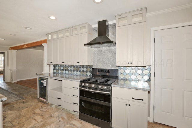 kitchen with backsplash, white cabinets, beverage cooler, double oven range, and wall chimney range hood