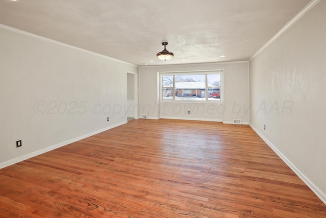 spare room featuring crown molding and light hardwood / wood-style floors