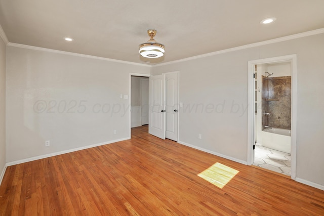 unfurnished bedroom with connected bathroom, hardwood / wood-style floors, and crown molding