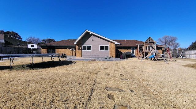 406 Bradley Ln, Dumas, TX 79029 - back of house with a playground and a trampoline