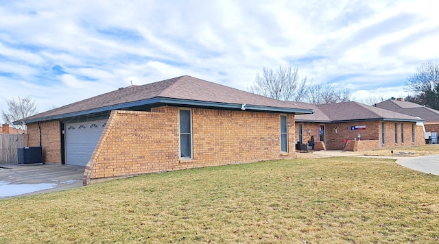 view of side of property with a garage, a lawn, and central air condition unit