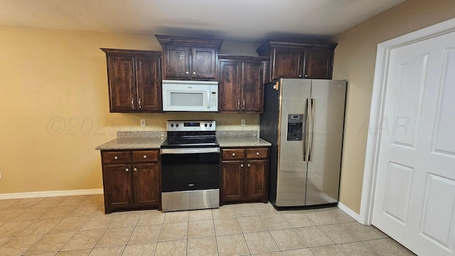 4207 Ross St, Amarillo, TX 79118 - kitchen featuring appliances with stainless steel finishes, dark brown cabinetry, and light tile patterned floors