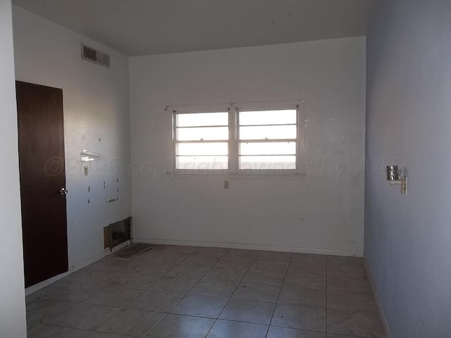 empty room featuring baseboards and visible vents