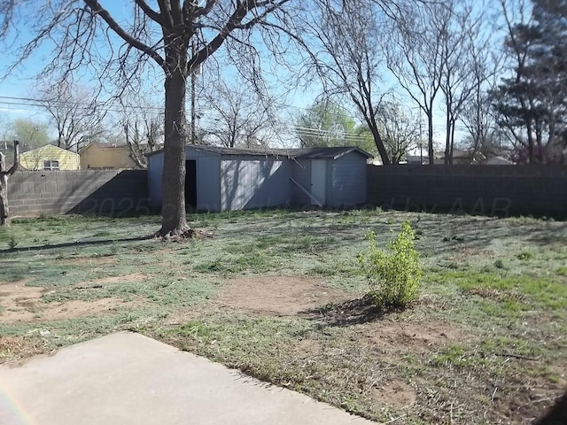 view of yard featuring a fenced backyard, an outbuilding, and a shed