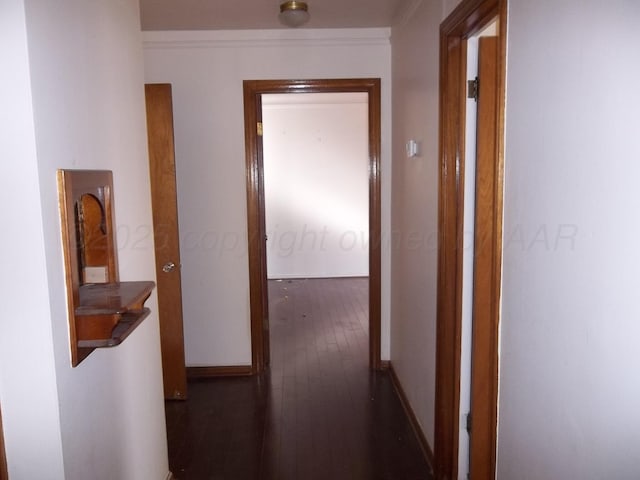corridor featuring hardwood / wood-style floors and baseboards