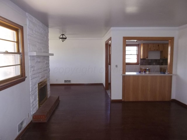 corridor featuring baseboards, visible vents, ornamental molding, and dark wood-style floors