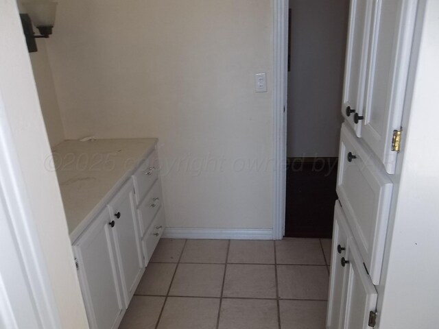 bathroom featuring baseboards, tile patterned floors, and vanity