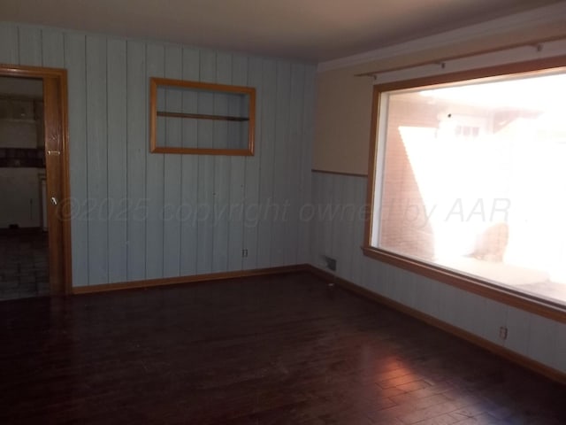empty room with baseboards and wood finished floors