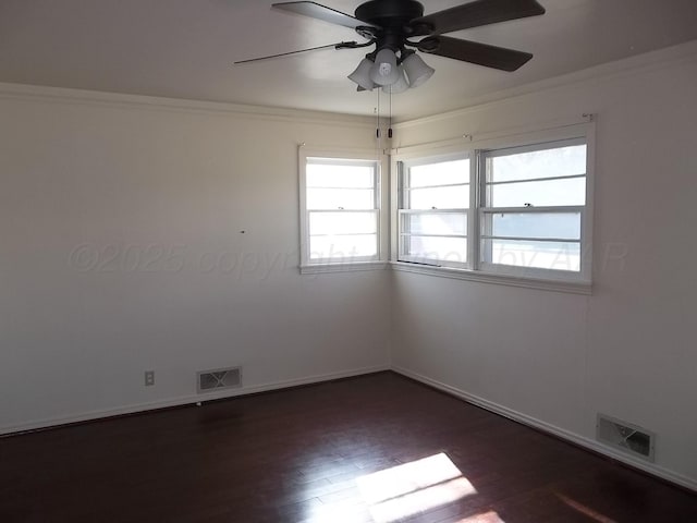 spare room with ornamental molding, dark wood-type flooring, and visible vents