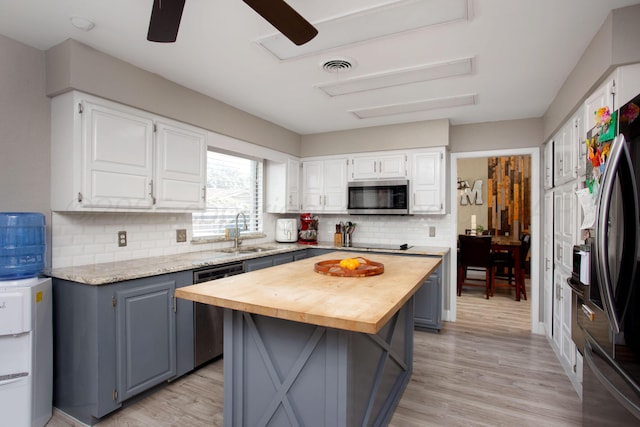 3506 Stromberg Pl, Amarillo, TX 79121 - kitchen with appliances with stainless steel finishes, wood counters, a ceiling fan, decorative backsplash, and white cabinets