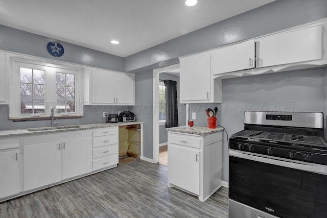 3701 Westlawn Ave, Amarillo, TX 79102 - kitchen featuring stainless steel gas range oven, light wood-type flooring, white cabinetry, recessed lighting, and light stone countertops