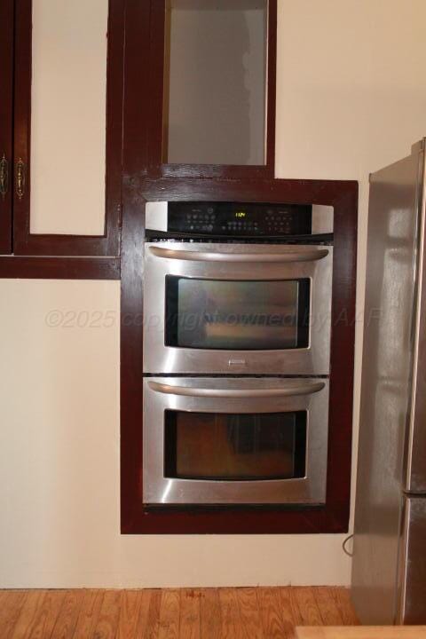 room details featuring appliances with stainless steel finishes and wood finished floors
